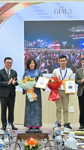 Tổng Biên tập Báo Nhân Dân Lê Quốc Minh và Phó Chủ tịch thường trực Hội Nhà báo Việt Nam Nguyễn Đức Lợi trao giải A cho các tác giả. (Ảnh: CTV/Vietnam+)