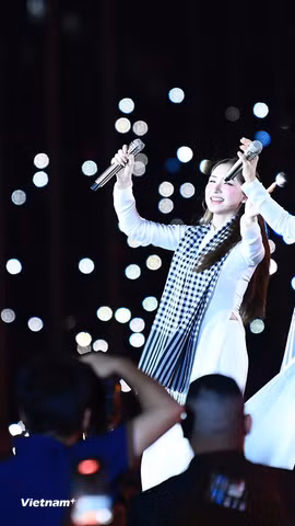 Cẩm Ly và Hòa Minzy thể hiện ca khúc “Người Việt mình thương nhau” trong đó cụm từ "lúa chín cúi đầu" được thay đổi. (Ảnh: PV/Vietnam+)