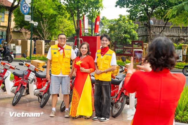 Mr. Nghiem Anh Quan (left) - founder of Honda Motorbike Road Club takes a photo with Hanoians who love classic Hondas. (Photo: Bao Ngoc/Vietnam+) vnp-xe-honda-co21.jpg
