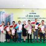 Đại diện Tập đoàn Lê Phong trao giấy chứng nhận quyền sở hữu căn hộ và hoa cho cư dân.