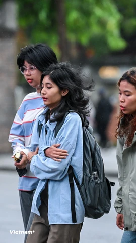 Những vị khách du lịch co ro trong trời lạnh vào sáng sớm ở Thủ đô. (Ảnh: Minh Sơn/Vietnam+)