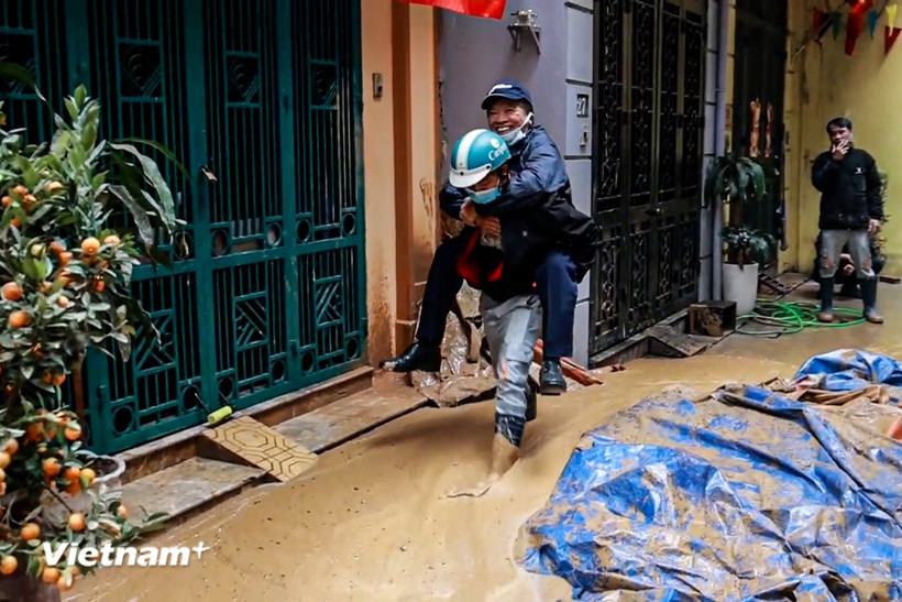 Người dân di chuyển khó khăn do bùn đất "phủ kín" con ngõ. (Ảnh: Minh Hiếu/Vietnam+)