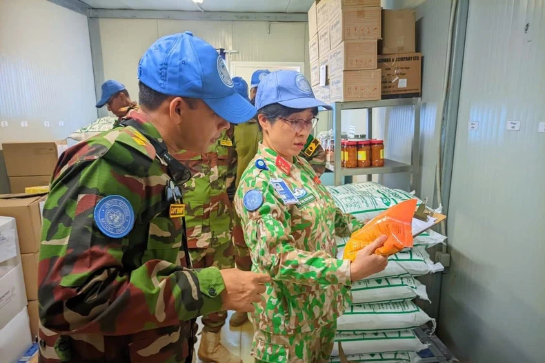 Trung tá Vũ Thị Kim Oanh kiểm tra kho lương thực khô tại tiểu đoàn bộ binh Bangladesh. (Ảnh: PV/Vietnam+)