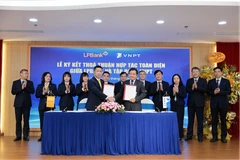 Ông Vũ Quốc Khánh, Tổng Giám đốc LPBank (trái) và ông Huỳnh Quang Liêm, Thành viên HĐTV kiêm Tổng Giám đốc Tập đoàn VNPT (phải) ký kết thoả thuận hợp tác toàn diện dưới sự chứng kiến của đại diện lãnh đạo hai bên. (Ảnh: Vietnam+)