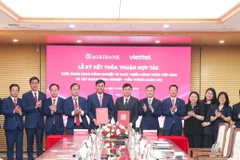 Đại diện Agribank và Viettel thực hiện nghi thức ký kết thỏa thuận hợp tác. (Ảnh: Vietnam+)