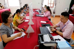 Ngay sau ngày 1/7 mô hình chính quyền địa phương 2 cấp chính thức đi vào hoạt động, Ngân hàng Chính sách xã hội chỉ đạo chi nhánh Ngân hàng Chính sách xã hội các tỉnh, thành phố duy trì thực hiện ngay việc giao dịch giải ngân thuận lợi cho người dân. (Ảnh: Vietnam+)