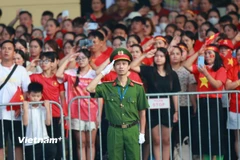 Các cưu chiến binh làm lễ chào cờ tại ngã tư Văn Miếu-Nguyễn Thái Học. (Ảnh: PV/Vietnam+)