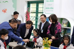 Đại diện Vietcombank cùng học sinh Trường THCS Tam Sơn, Bắc Ninh trải nghiệm không gian học tập tại “Thư viện Xanh” do ngân hàng trao tặng. (Ảnh: Vietnam+)