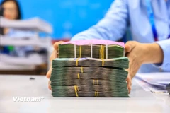 Một số ngân hàng bắt đầu thu phí với tài khoản có số dư dưới 500.000 đồng. (Ảnh: Vietnam+)