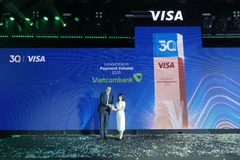 Đại diện Vietcombank, bà Đoàn Hồng Nhung – Thành viên Ban điều hành, Giám đốc Khối bán lẻ nhận giải thưởng “Leadership in Payment Volume – Ngân hàng dẫn đầu về tổng doanh số giao dịch năm 2025” từ đại diện Visa. (Ảnh: Vietnam+)
