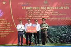 Thiếu tướng Đinh Văn Nơi - Cục trưởng Cục An ninh chính trị nội bộ, Bộ Công an (ngoài cùng bên phải) và ông Lê Hoàng Tùng – Phó Tổng Giám đốc Vietcombank (ngoài cùng bên trái) trao bảng tượng trưng số tiền tài trợ xây dựng 4 cầu giao thông nông thôn tặng huyện Giồng Trôm, tỉnh Bến Tre. (Ảnh: Vietnam+)