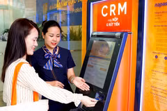 Nhân viên SHB hướng dẫn khách hàng sử dụng máy CRM. (Ảnh: Vietnam+)