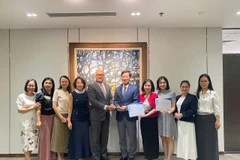 Đại diện Vietcombank, ông Vũ Quang Đông - Phó Giám đốc Khối phụ trách điều hành Khối vốn & Thị trường (đứng thứ 5 từ phải sang) nhận giải thưởng từ đại diện Ngân hàng J.P. Morgan Chase, ông Madhav Kalyan - Giám đốc Điều hành phụ trách Khối Dịch vụ thanh toán Khu vực Châu Á - Thái Bình Dương. (Ảnh: Vietnam+)