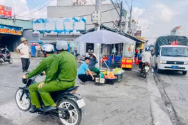 Đại úy Bùi Thanh Tuấn điều khiển xe máy không gắn kiếng hậu khi làm nhiệm vụ. (Ảnh: PV/Vietnam+)