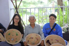 Các bạn trẻ thích thú với workshop nón lá. (Ảnh: PV/Vietnam+)