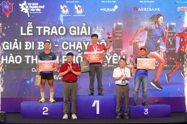 Ông Nguyễn Đức Lợi, Phó Chủ tịch Thường trực Hội Nhà báo Việt Nam trao giải thưởng cho các vận động viên. (Ảnh: TTXVN)