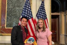 Bà Brette Carolyn Powell - Trợ lý Tổng thống đại diện nhận món quà tặng từ Nghệ nhân Hồ Thanh Tuấn. (Ảnh: PV/Vietnam+)