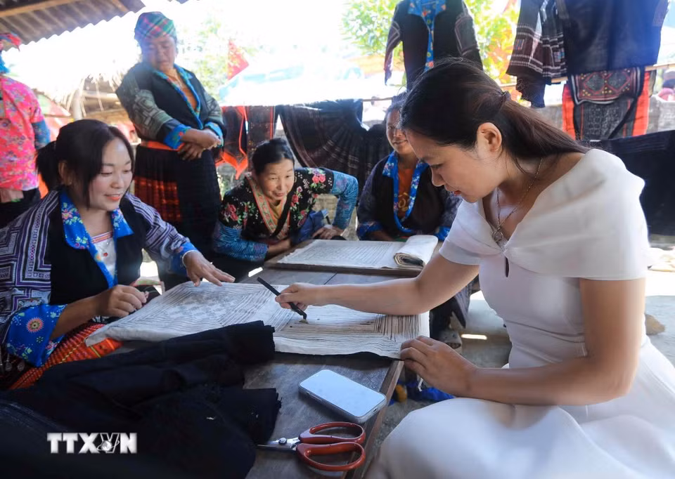 Du khách trải nghiệm kỹ thuật tạo hoa văn trên vải lanh của phụ nữ dân tộc Mông tại bản Tù Lu-Tìa Ló. (Ảnh: Xuân Tư/TTXVN)