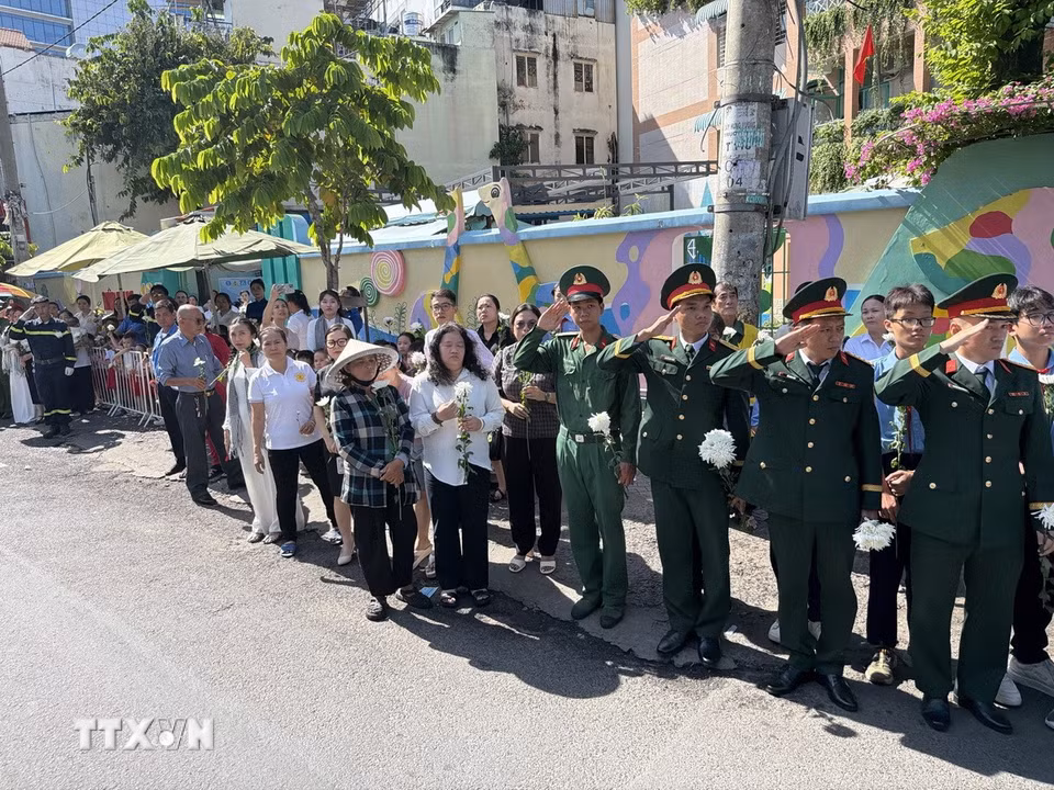 Đông đảo các tầng lớp nhân dân đứng dọc hai bên đường tiễn đưa, tưởng nhớ các Anh hùng liệt sỹ được quy tập tại Công viên Lê Thị Riêng về nơi an táng. (Ảnh: Trung Tuyến/TTXVN)