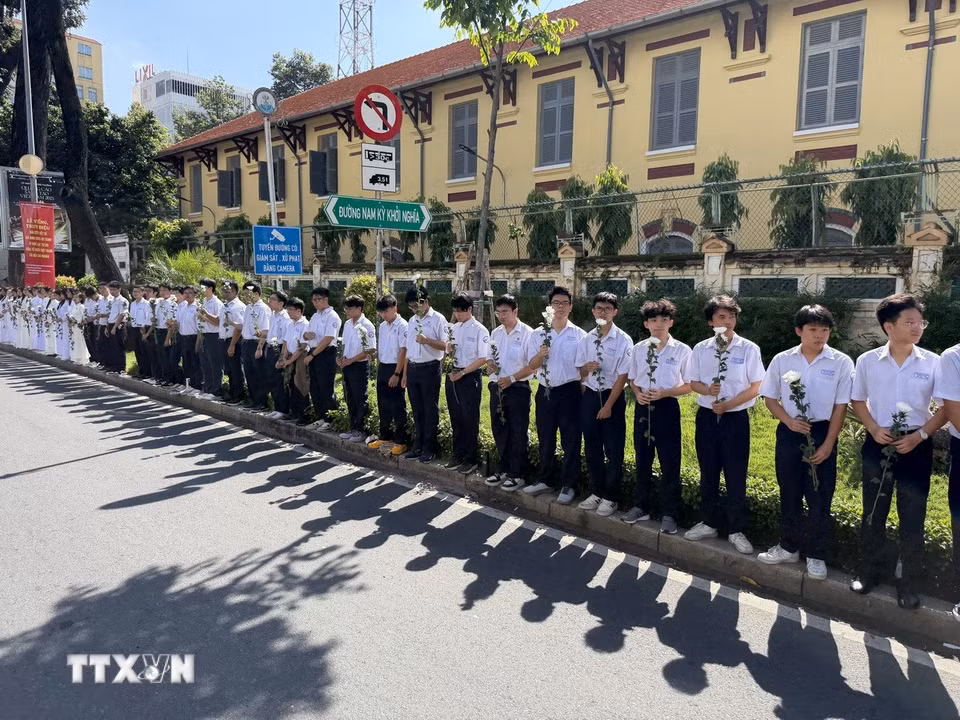 Đông đảo các tầng lớp nhân dân đứng dọc hai bên đường tiễn đưa, tưởng nhớ các Anh hùng liệt sỹ được quy tập tại Công viên Lê Thị Riêng về nơi an táng. (Ảnh: Trung Tuyến/TTXVN)