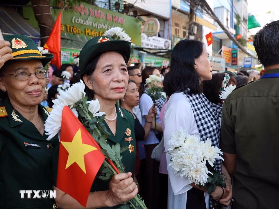Đông đảo người dân Thành phố chờ tiễn đưa các Anh hùng liệt sỹ về an táng tại Nghĩa trang Thành phố. (Ảnh: Xuân Khu/TTXVN)