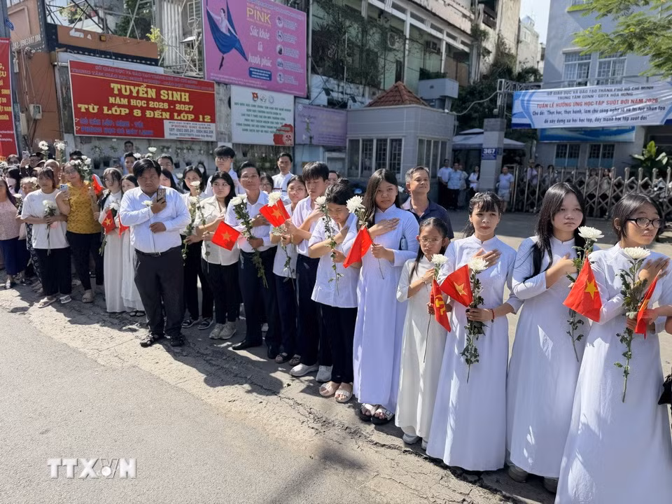 Đông đảo các tầng lớp nhân dân đứng dọc hai bên đường tiễn đưa, tưởng nhớ các Anh hùng liệt sỹ được quy tập tại Công viên Lê Thị Riêng về nơi an táng. (Ảnh: Trung Tuyến/TTXVN)