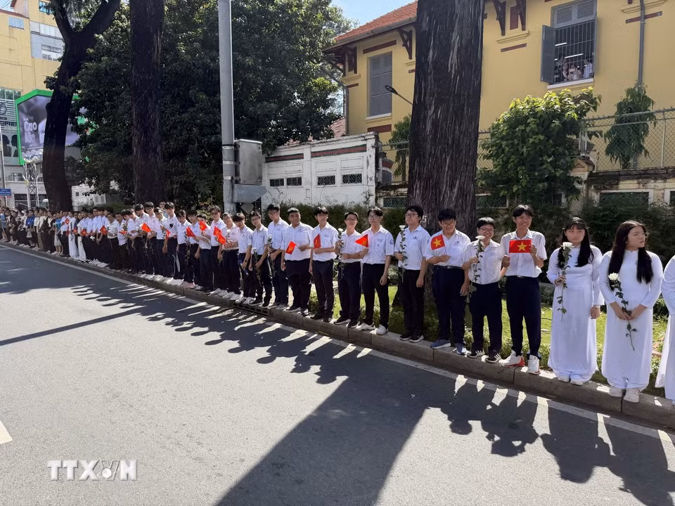 Đông đảo các tầng lớp nhân dân đứng dọc hai bên đường tiễn đưa, tưởng nhớ các Anh hùng liệt sỹ được quy tập tại Công viên Lê Thị Riêng về nơi an táng. (Ảnh: Trung Tuyến/TTXVN)