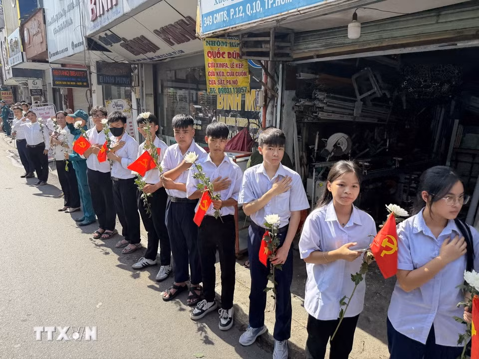 Đông đảo các tầng lớp nhân dân đứng dọc hai bên đường tiễn đưa, tưởng nhớ các Anh hùng liệt sỹ được quy tập tại Công viên Lê Thị Riêng về nơi an táng. (Ảnh: Trung Tuyến/TTXVN)