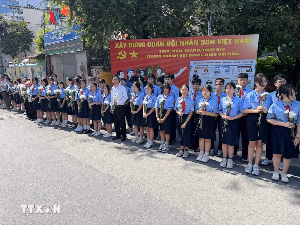 Đông đảo các tầng lớp nhân dân đứng dọc hai bên đường tiễn đưa, tưởng nhớ các Anh hùng liệt sỹ được quy tập tại Công viên Lê Thị Riêng về nơi an táng. (Ảnh: Trung Tuyến/TTXVN)
