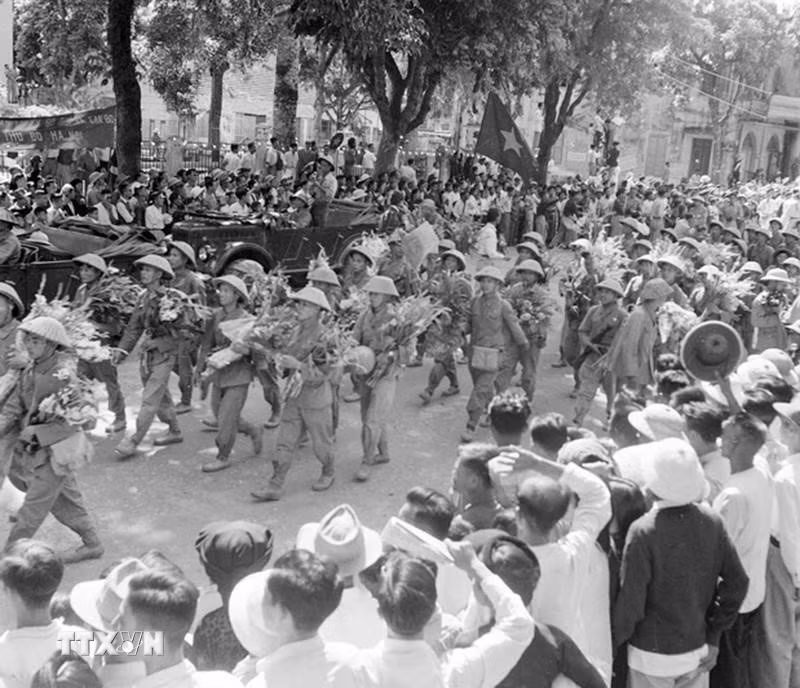Sáng 10/10/1954, cả Hà Nội ngập tràn cờ, hoa, biểu ngữ trong ngày hội lớn. Thủ đô bừng tiến quân ca của lớp lớp đoàn quân tiến về giải phóng, kết thúc vẻ vang 9 năm trường kỳ kháng chiến chống thực dân Pháp. Bộ đội thuộc hai Trung đoàn 88 và 36 của Đại đoàn 308 tiến qua tuyến đường phố Bạch Mai, phố Huế… vào tiếp quản Thủ đô. (Ảnh: Tư liệu TTXVN)