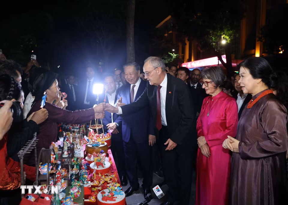 Tổng thống Thụy Sĩ Guy Parmelin và Phu nhân bày tỏ sự thích thú với sản phẩm tò he truyền thống do các nghệ nhân làng nghề Xuân La sáng tạo nên. (Ảnh: Thống Nhất/TTXVN)