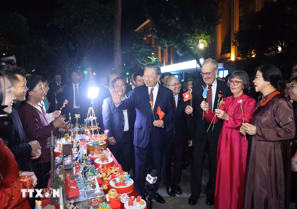 Tổng Bí thư, Chủ tịch nước Tô Lâm và Phu nhân cùng Tổng thống Thụy Sĩ Guy Parmelin và Phu nhân tham quan sạp tò he của những nghệ nhân làng Xuân La - nét văn hóa dân gian độc đáo trên phố đi bộ hồ Hoàn Kiếm. (Ảnh: Thống Nhất/TTXVN)