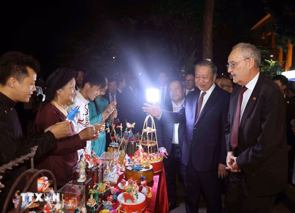 Tổng Bí thư, Chủ tịch nước Tô Lâm giới thiệu với Tổng thống Thụy Sĩ Guy Parmelin về nghệ thuật tò he - nét văn hóa dân gian độc đáo trên phố đi bộ. (Ảnh: Thống Nhất/TTXVN)