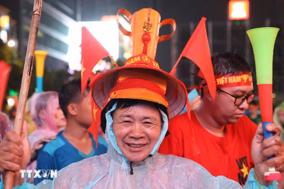 Cổ động viên trong trang phục mang sắc đỏ, sẵn sàng tiếp lửa đội tuyển Việt Nam. (Ảnh: Hồng Đạt/TTXVN)