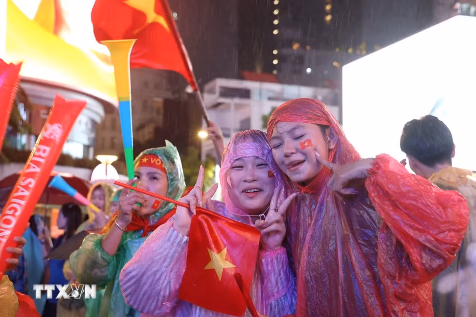 Người hâm mộ Thành phố Hồ Chí Minh đội mưa chờ đợi Việt Nam vô địch bóng đá Đông Nam Á lần thứ 4. (Ảnh: Hồng Đạt/TTXVN)