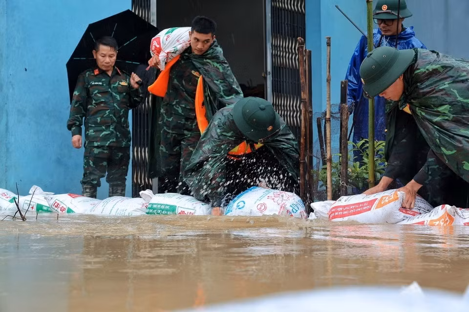 Cán bộ, chiến sỹ Trung đoàn 102 xếp các bao vật liệu tạo tuyến ngăn nước, bảo vệ nhà dân tại xã Quảng Bị. (Ảnh: Phạm Tuấn Anh/TTXVN)