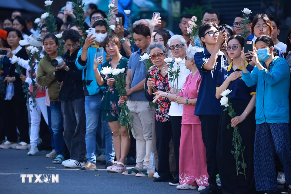 Đông đảo nhân dân Thành phố Hồ Chí Minh với nhành hoa trắng trên tay đưa tiễn hài cốt các Anh hùng liệt sỹ về Nghĩa trang liệt sỹ Thành phố Hồ Chí Minh. (Ảnh: Dương Giang/TTXVN)