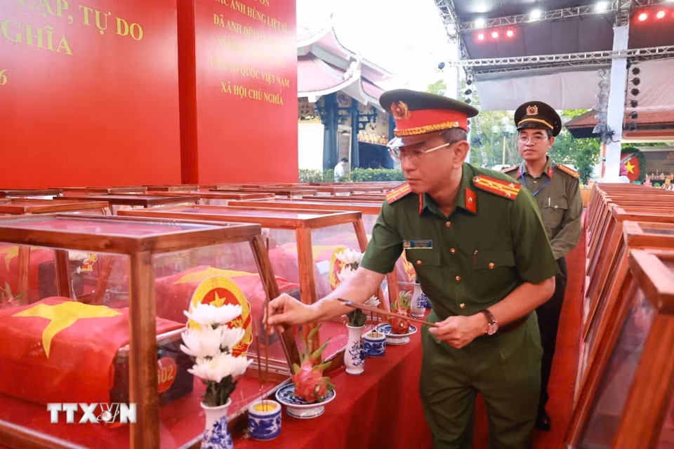 Cán bộ, chiến sỹ lực lượng vũ trang thắp hương tưởng niệm các anh hùng liệt sỹ lần cuối trước khi đưa hài cốt các Anh rời Công viên Lê Thị Riêng về Nghĩa trang liệt sỹ Thành phố Hồ Chí Minh. (Ảnh: Dương Giang/TTXVN)