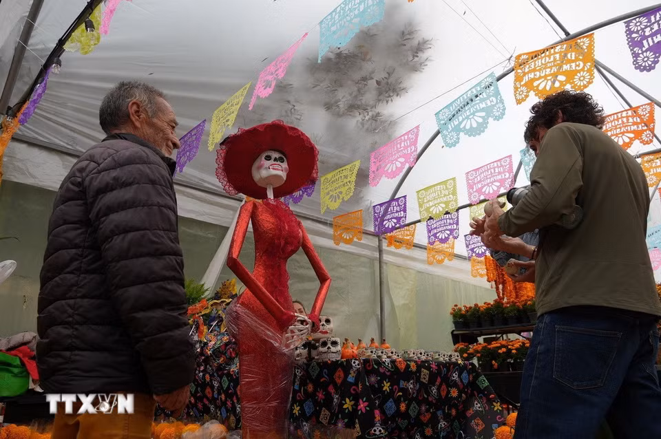 Một quầy bán cúc vạn thọ (Cempasúchil) được trang trí bởi mô hình La Catrina - biểu tượng Ngày của người chết. (Ảnh: Phi Hùng/TTXVN)