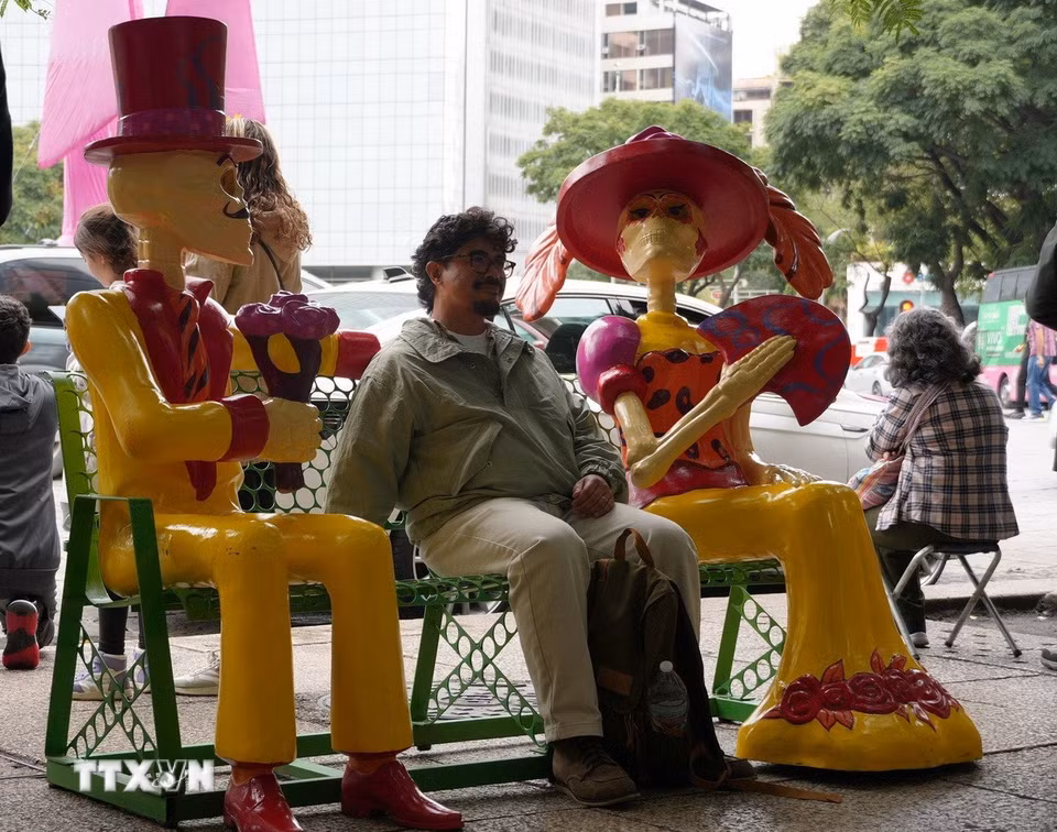 Người dân chụp ảnh cùng mô hình "người chết" tại trung tâm thủ đô Mexico City. (Ảnh: Phi Hùng/TTXVN)