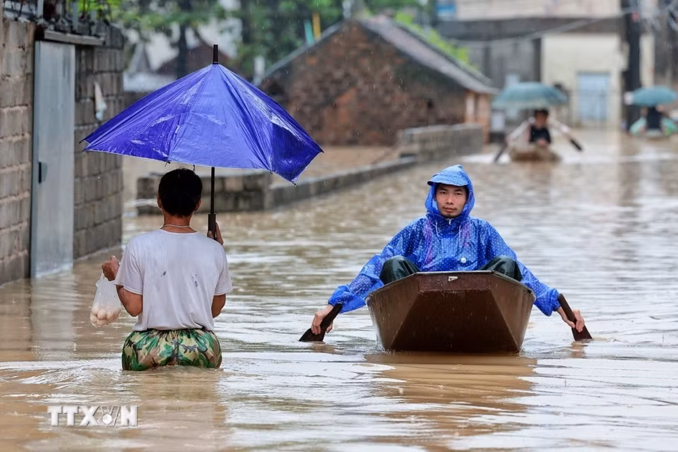Nước lũ dâng cao, người dân phải sử dụng thuyền nhỏ để di chuyển tại xã Quảng Bị, Hà Nội. (Ảnh: Phạm Tuấn Anh/TTXVN)
