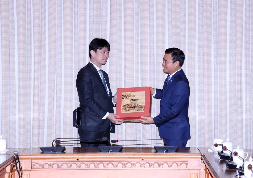 Phó Chủ tịch Ủy ban Nhân dân Thành phố Hồ Chí Minh Bùi Xuân Cường (phải) trao quà đối ngoại cho Thứ trưởng Bộ Ngoại giao Nhật Bản Komura Masahiro. (Ảnh: Xuân Khu/TTXVN)