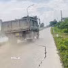 Phương tiện hàng ngày vẫn lưu thông qua những đoạn đê sông Nhuệ (xã Chuyên Mỹ) bị rạn nứt ảnh hưởng lớn đến an toàn đê. (Ảnh: Tuyết Mai/TTXVN)