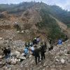 Các lực lượng gồm công an quân đội biên phòng có mặt tại hiện trường để cứu hộ các nạn nhân. (Ảnh: Nguyễn Oanh/TTXVN)