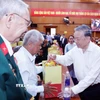 Tổng Bí thư Tô Lâm tặng quà cho đại diện gia đình chính sách, người có công. (Ảnh: Thống Nhất/TTXVN)