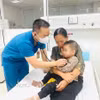 Bác siỹ thăm khám sau khi bệnh nhi được gắp dị vật mắc trong thực quản và sức khỏe dần ổn định. (Ảnh: TTXVN phát)