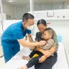 Bác siỹ thăm khám sau khi bệnh nhi được gắp dị vật mắc trong thực quản và sức khỏe dần ổn định. (Ảnh: TTXVN phát)