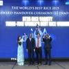 Anh Hùng lao động Hồ Quang Cua cùng các con nâng cao cúp "Gạo ngon nhất thế giới" năm 2025 tại buổi lễ. (Ảnh: Nguyễn Văn Việt/TTXVN)
