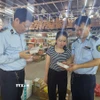 Lực lượng Quản lý thị trường kiểm tra, đồng thời tuyên truyền phổ biến pháp luật cho người dân. (Ảnh: TTXVN phát)
