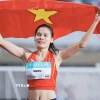 Vận động viên điền kinh Nguyễn Thị Ngọc với lá cờ Tổ quốc sau khi giành huy chương Vàng chạy 400m nữ tại SEA Games 33. (Ảnh: Minh Quyết/TTXVN)